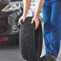 man rolling a car tire